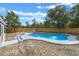 Backyard view of the kidney-shaped pool with concrete surround and wooden fence at 2763 E Waco Dr, Deltona, FL 32738
