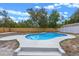 Backyard view showcasing a kidney-shaped pool with blue tile and concrete surround, framed by a wooden fence at 2763 E Waco Dr, Deltona, FL 32738