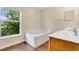 Bathroom featuring a garden tub and a window offering natural light, along with a mirrored vanity at 2995 White Magnolia Loop, Clermont, FL 34711