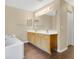Bathroom with dual sinks, a large mirror, vanity lighting and a separate tub at 2995 White Magnolia Loop, Clermont, FL 34711