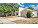 Exterior view of a two-story home, driveway, garage, and well maintained yard and mature trees at 2995 White Magnolia Loop, Clermont, FL 34711