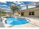 Backyard pool with screen enclosure, patio area, and views of neighboring houses and blue skies in the background at 2995 White Magnolia Loop, Clermont, FL 34711