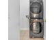 Laundry room featuring a stacked washer and dryer with neutral tile flooring at 314 Lady Diana Dr, Davenport, FL 33837
