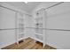 Walk-in closet with wood floor, and white adjustable shelving, and hanging rods at 314 Lady Diana Dr, Davenport, FL 33837