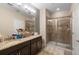 Stylish bathroom featuring dual sinks, a granite countertop, and a tiled walk-in shower at 3333 Messina Dr, Lake Mary, FL 32746