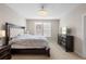 Well-lit bedroom with a large bed, dresser, and abundant natural light from two windows at 3333 Messina Dr, Lake Mary, FL 32746