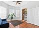 Bright room with wood floors, built-in shelves, a ceiling fan and a large window at 346 Hickory Springs Ct, Debary, FL 32713