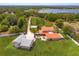 Aerial view of a home with copper roof, a detached garage and views of a pond in the distance at 36408 E Eldorado Lake Dr, Eustis, FL 32736