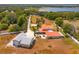 An aerial view of a home with metal roof, outbuildings, and ample parking at 36408 E Eldorado Lake Dr, Eustis, FL 32736