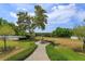 Well-manicured backyard with a fountain, lush landscaping, and a serene view of trees at 36408 E Eldorado Lake Dr, Eustis, FL 32736