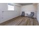 Basement area with concrete walls, wood floors, and natural light from a window at 36408 E Eldorado Lake Dr, Eustis, FL 32736