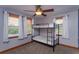 Bedroom with a bunk bed, ceiling fan, and natural light from two windows at 36408 E Eldorado Lake Dr, Eustis, FL 32736