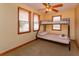 Cozy bedroom with a bunk bed, ceiling fan, and natural light from two windows at 36408 E Eldorado Lake Dr, Eustis, FL 32736