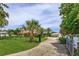 Long, paved driveway leading to a home and detached garage, with mature trees and manicured lawn at 36408 E Eldorado Lake Dr, Eustis, FL 32736
