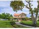 Two-story home with copper roof, lush front yard, mature trees, a fountain and a winding walkway at 36408 E Eldorado Lake Dr, Eustis, FL 32736