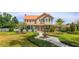Inviting two-story home with a manicured lawn and decorative fountain at 36408 E Eldorado Lake Dr, Eustis, FL 32736