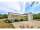 A spacious, light green garage with an expansive concrete driveway and outdoor seating area at 36408 E Eldorado Lake Dr, Eustis, FL 32736