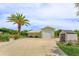Spacious detached garage with a wide driveway, complemented by a lush green lawn and mature palm tree at 36408 E Eldorado Lake Dr, Eustis, FL 32736