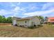Light green garage with a roll up door, landscaping, and space for outdoor projects at 36408 E Eldorado Lake Dr, Eustis, FL 32736