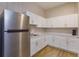 Kitchenette featuring white cabinets, stainless steel refrigerator, and wood floors at 36408 E Eldorado Lake Dr, Eustis, FL 32736