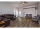Spacious living room featuring wood floors, a leather sofa, and a roll-up garage door at 36408 E Eldorado Lake Dr, Eustis, FL 32736