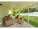 Inviting covered patio with wicker chairs, perfect for outdoor relaxation and enjoying the landscaped backyard at 36408 E Eldorado Lake Dr, Eustis, FL 32736