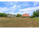 Spacious property featuring the main house, garage, and surrounding green spaces under a clear sky at 36408 E Eldorado Lake Dr, Eustis, FL 32736
