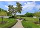 A beautifully landscaped yard featuring a fountain and pathway, adding elegance and charm to the outdoor space at 36408 E Eldorado Lake Dr, Eustis, FL 32736
