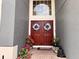 Inviting front entrance with double doors, decorative wreaths, seasonal flowers and a Buddha statue at 405 Bella Vida Blvd, Orlando, FL 32828