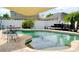 Relaxing backyard pool area with a shade sail, table, chairs, and lounge chairs at 405 Bella Vida Blvd, Orlando, FL 32828