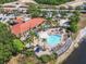 An aerial view of the community pool and clubhouse with lush landscaping and lake at 411 Cabello Dr, Davenport, FL 33837