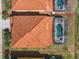 An aerial view showing a house with a red tiled roof and screened-in pool at 411 Cabello Dr, Davenport, FL 33837