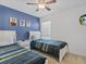 Bedroom with two twin beds, blue accent wall, and ceiling fan at 411 Cabello Dr, Davenport, FL 33837
