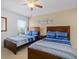 This bright bedroom has two beds, a ceiling fan and natural light at 411 Cabello Dr, Davenport, FL 33837