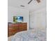 Bedroom features a ceiling fan, closet, and wooden dresser with a TV screen on top at 411 Cabello Dr, Davenport, FL 33837