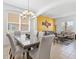 Open-concept dining room features a glass table and modern chandelier, seamlessly connecting living spaces at 411 Cabello Dr, Davenport, FL 33837