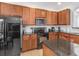 Well-equipped kitchen featuring wood cabinetry, black appliances, granite countertops and a central island at 411 Cabello Dr, Davenport, FL 33837