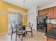 Eat-in kitchen area featuring a glass table, tile floors, and wooden cabinets, with sliding glass doors to screened porch at 411 Cabello Dr, Davenport, FL 33837