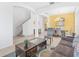 Spacious living area with tile flooring, staircase, and bright color scheme in an open-concept design at 411 Cabello Dr, Davenport, FL 33837