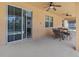 A covered patio with a ceiling fan, large sliding glass door, and outdoor dining set at 411 Cabello Dr, Davenport, FL 33837