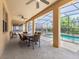 Covered patio with ceiling fans and an outdoor table overlooking a pool and wooded backyard at 411 Cabello Dr, Davenport, FL 33837