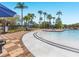 An inviting zero entry pool area features poolside seating, tall palm trees, and sunny skies at 411 Cabello Dr, Davenport, FL 33837