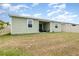 Full view of back yard with patio, green siding and a fence at 4351 Finch Ln, Kissimmee, FL 34746