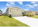 Exterior shot of a well-maintained one-story home, with a 2-car garage and manicured front lawn at 4351 Finch Ln, Kissimmee, FL 34746