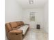 Small room with leather sofa, tile flooring and small window to the back yard at 4351 Finch Ln, Kissimmee, FL 34746