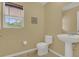 Small bathroom featuring a pedestal sink, toilet, window, and nautical-themed decor at 5056 Gandross Ln, Mount Dora, FL 32757
