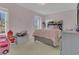 Bright bedroom featuring neutral carpet, light pink walls, and a charming ruffled comforter on a full sized bed at 5056 Gandross Ln, Mount Dora, FL 32757