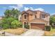 Inviting home featuring a well-manicured lawn, mature landscaping, and an attached two-car garage in a suburban setting at 5056 Gandross Ln, Mount Dora, FL 32757