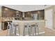 Kitchen showcasing a breakfast bar with seating, stainless steel appliances and dark cabinetry at 5056 Gandross Ln, Mount Dora, FL 32757