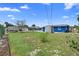 The home features a sizable backyard with grass, partial fencing, and other homes nearby at 507 Raymond Ave, Frostproof, FL 33843